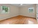 Bedroom featuring hardwood floors, two windows, and neutral walls with an overhead fan at 702 Wedgewood Ave, Zebulon, NC 27597