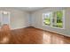 Bright bedroom with gleaming hardwood floors and a large window with views of the outdoors at 702 Wedgewood Ave, Zebulon, NC 27597