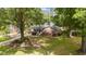 A charming front exterior features a well-manicured lawn and mature trees at 702 Wedgewood Ave, Zebulon, NC 27597