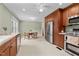 Spacious kitchen with stainless steel appliances, wooden cabinetry and a breakfast nook with a round table at 702 Wedgewood Ave, Zebulon, NC 27597