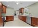 Open kitchen with stainless steel appliances, wooden cabinetry and a view of a laundry area at 702 Wedgewood Ave, Zebulon, NC 27597