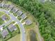 Aerial view of a residential neighborhood with houses, manicured lawns, and walking trails around a pond and wooded area at 704 Long Lake Dr, Fuquay Varina, NC 27526