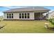 A well-maintained backyard featuring a lawn, patio, and an exterior view of the home with large windows at 704 Long Lake Dr, Fuquay Varina, NC 27526