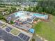 Aerial view of a community pool featuring multiple pools, lounge chairs, a playground, and ample parking at 704 Long Lake Dr, Fuquay Varina, NC 27526