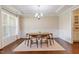 Bright dining room with large window, hardwood floors, and modern chandelier at 704 Long Lake Dr, Fuquay Varina, NC 27526