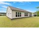 Exterior view of a home showcasing a large backyard with lush green grass and several windows at 704 Long Lake Dr, Fuquay Varina, NC 27526