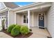 Inviting front porch with a decorative wreath on the front door and manicured landscaping at 704 Long Lake Dr, Fuquay Varina, NC 27526
