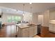 Kitchen island with granite counters, sink, and stainless steel dishwasher overlooking an open floorplan living room at 704 Long Lake Dr, Fuquay Varina, NC 27526