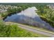 Aerial view of a large pond surrounded by lush greenery and reflecting the sky at 704 Long Lake Dr, Fuquay Varina, NC 27526