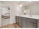 Bright bathroom featuring double vanity with white countertops and grey cabinetry next to primary bedroom at 712 Emmer St, Rolesville, NC 27571