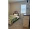 Cozy bedroom with stylish bed frame, floral pillows, and bright window with plantation shutters at 712 Emmer St, Rolesville, NC 27571