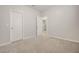 Bedroom with neutral walls and carpet, featuring two entry doors and ample natural light at 712 Emmer St, Rolesville, NC 27571