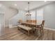 Bright dining room with a large wooden table, bench seating, modern chandelier, and wood-look flooring at 712 Emmer St, Rolesville, NC 27571