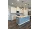 Bright kitchen with an island, stainless appliances, white cabinets, and hardwood floors at 712 Emmer St, Rolesville, NC 27571