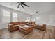 Spacious living room with natural light, ceiling fan, and a large leather sectional at 712 Emmer St, Rolesville, NC 27571