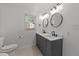 Bright bathroom featuring double sinks, modern fixtures and tile flooring at 7204 Laketree Dr, Raleigh, NC 27615