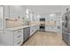 Modern eat in kitchen featuring white cabinets, stainless appliances and light wood flooring at 7204 Laketree Dr, Raleigh, NC 27615