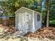 Backyard utility shed with a ramp and classic white door at 7204 Laketree Dr, Raleigh, NC 27615
