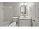 Clean bathroom with a white vanity, an oval mirror, a toilet, and a tiled shower-tub combination at 7340 Doverton Ct, Raleigh, NC 27615