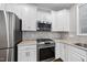 Updated kitchen featuring stainless steel appliances, white cabinets, and tile backsplash at 7340 Doverton Ct, Raleigh, NC 27615
