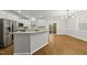 Bright eat-in kitchen features white cabinets, stainless steel appliances, and dark hardwood flooring at 7340 Doverton Ct, Raleigh, NC 27615
