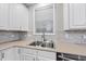 Kitchen sink with stainless steel faucet, white cabinetry and tile backsplash at 7340 Doverton Ct, Raleigh, NC 27615