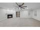 Spacious living room with a fireplace, ceiling fan, and sliding glass door for natural light at 7340 Doverton Ct, Raleigh, NC 27615