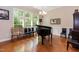 Elegant dining area with large windows, hardwood floors, a piano, and a chandelier at 7660 Channery Way, Raleigh, NC 27616