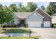 Charming home featuring a two-car garage, stone accents, a well-manicured lawn, and a welcoming entrance at 7660 Channery Way, Raleigh, NC 27616