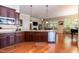 Open kitchen with stainless appliances, granite countertops, hardwood floors, and view into the living room at 7660 Channery Way, Raleigh, NC 27616