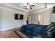 Spacious main bedroom with a tray ceiling, ceiling fan, and hardwood floors at 7660 Channery Way, Raleigh, NC 27616