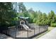 A fenced playground is shown with climbing structures and slides, ideal for Gathering fun and recreation at 7660 Channery Way, Raleigh, NC 27616