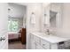 Bathroom vanity with white cabinetry, faucet, hardware, mirror and access to bedroom at 7761 Winners Edge St, Raleigh, NC 27617