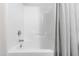 Clean white tub and shower combination with gray and white curtain at 7761 Winners Edge St, Raleigh, NC 27617