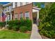 Close-up of a townhome entrance with lush green hedges and a walkway leading to the front door at 7761 Winners Edge St, Raleigh, NC 27617