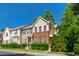A classic townhome with brick and siding, complemented by green landscaping and a vibrant blue sky backdrop at 7761 Winners Edge St, Raleigh, NC 27617