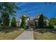 Inviting clubhouse featuring covered entrance, manicured lawn, and brick accents beneath a clear blue sky at 7761 Winners Edge St, Raleigh, NC 27617