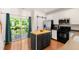 Bright kitchen with stainless appliances, island, white cabinets, and sliding glass doors at 7761 Winners Edge St, Raleigh, NC 27617
