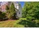 Side view of a townhome's yard with a manicured lawn and mature trees offering shade and privacy at 7761 Winners Edge St, Raleigh, NC 27617