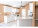 Bright kitchen featuring white cabinetry, tiled countertops, stainless steel appliances, and a breakfast bar at 78 Cross Creek Ct, Timberlake, NC 27583