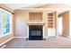 Cozy living room featuring a fireplace, built-in shelving, neutral tones, and soft carpeting at 78 Cross Creek Ct, Timberlake, NC 27583