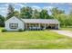 Charming single-Gathering home featuring a welcoming front porch and attached carport with a metal roof at 80 Lewis Moody Rd, Bear Creek, NC 27207