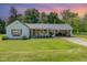 Charming single-Gathering home featuring a welcoming front porch and attached carport with a metal roof at 80 Lewis Moody Rd, Bear Creek, NC 27207