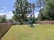 The large backyard includes a playset, shade trees, and a wood privacy fence at 808 Trinity Park Dr, Wake Forest, NC 27587