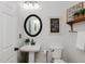 Charming powder room featuring pedestal sink, decorative mirror, and unique wall decor at 808 Trinity Park Dr, Wake Forest, NC 27587