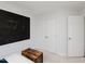 Simple bedroom with a black accent wall, wooden furniture, and white doors at 808 Trinity Park Dr, Wake Forest, NC 27587