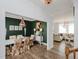 Elegant dining room featuring a chandelier, green accent wall, and a view of the living room at 808 Trinity Park Dr, Wake Forest, NC 27587