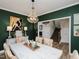 Dining room with stylish chandelier, green walls, and a view of the staircase at 808 Trinity Park Dr, Wake Forest, NC 27587