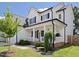 Charming two-story home featuring a welcoming front porch, white siding, black trim, and manicured landscaping at 808 Trinity Park Dr, Wake Forest, NC 27587