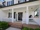 Inviting covered front porch with seating area, wreath, and decor at 808 Trinity Park Dr, Wake Forest, NC 27587